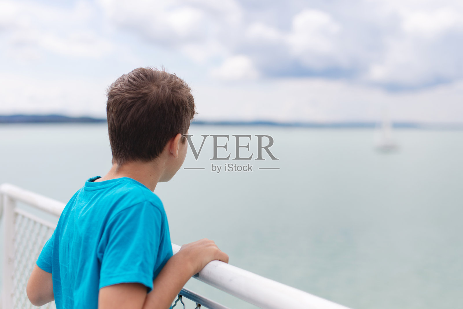 小男孩在远处看着帆船照片摄影图片