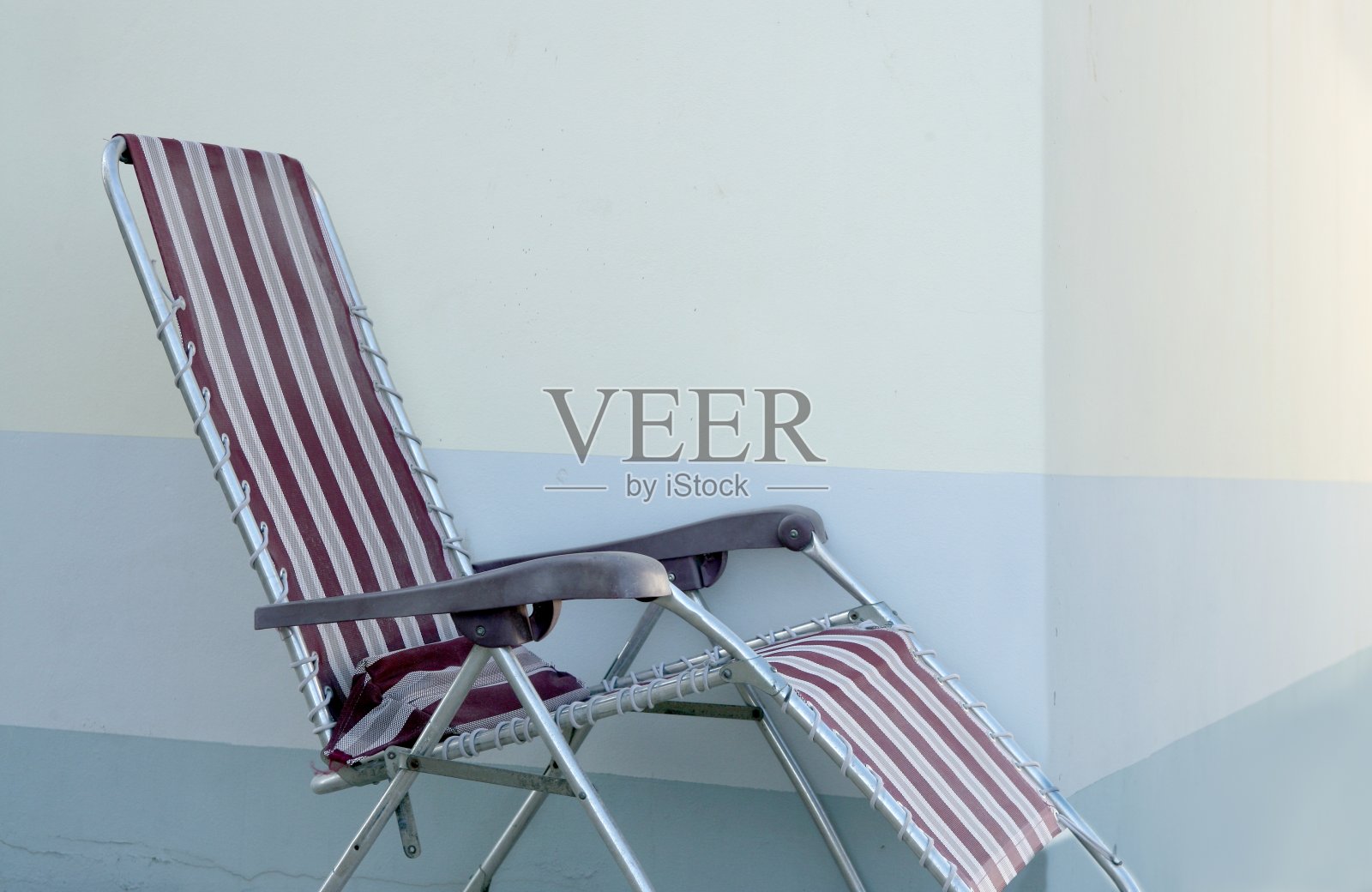 蓝色背景墙上独自的夏日椅子照片摄影图片