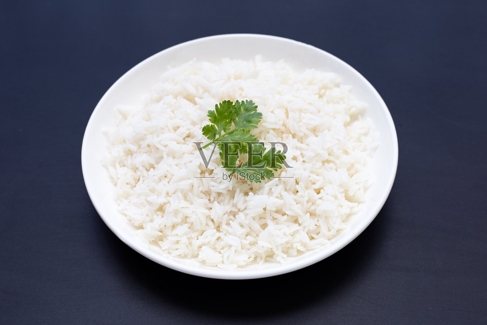 一盘米饭放在深色的背景上。照片摄影图片