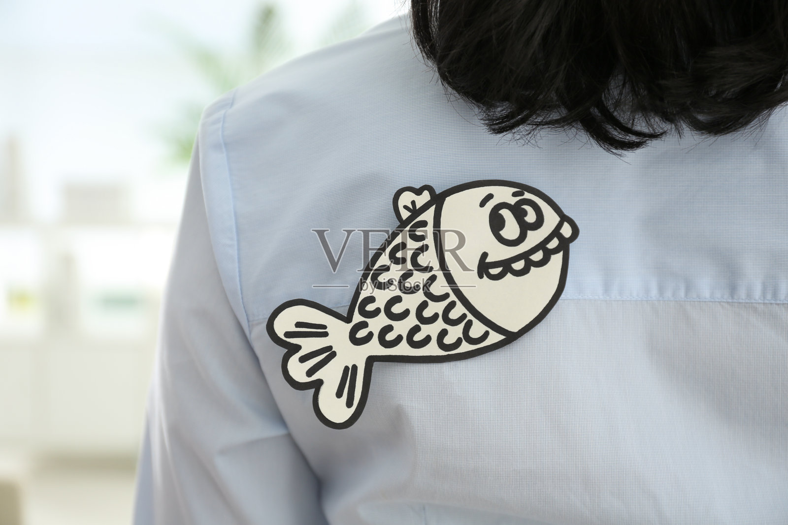 背着纸鱼的女人在室内，特写镜头。愚人节照片摄影图片