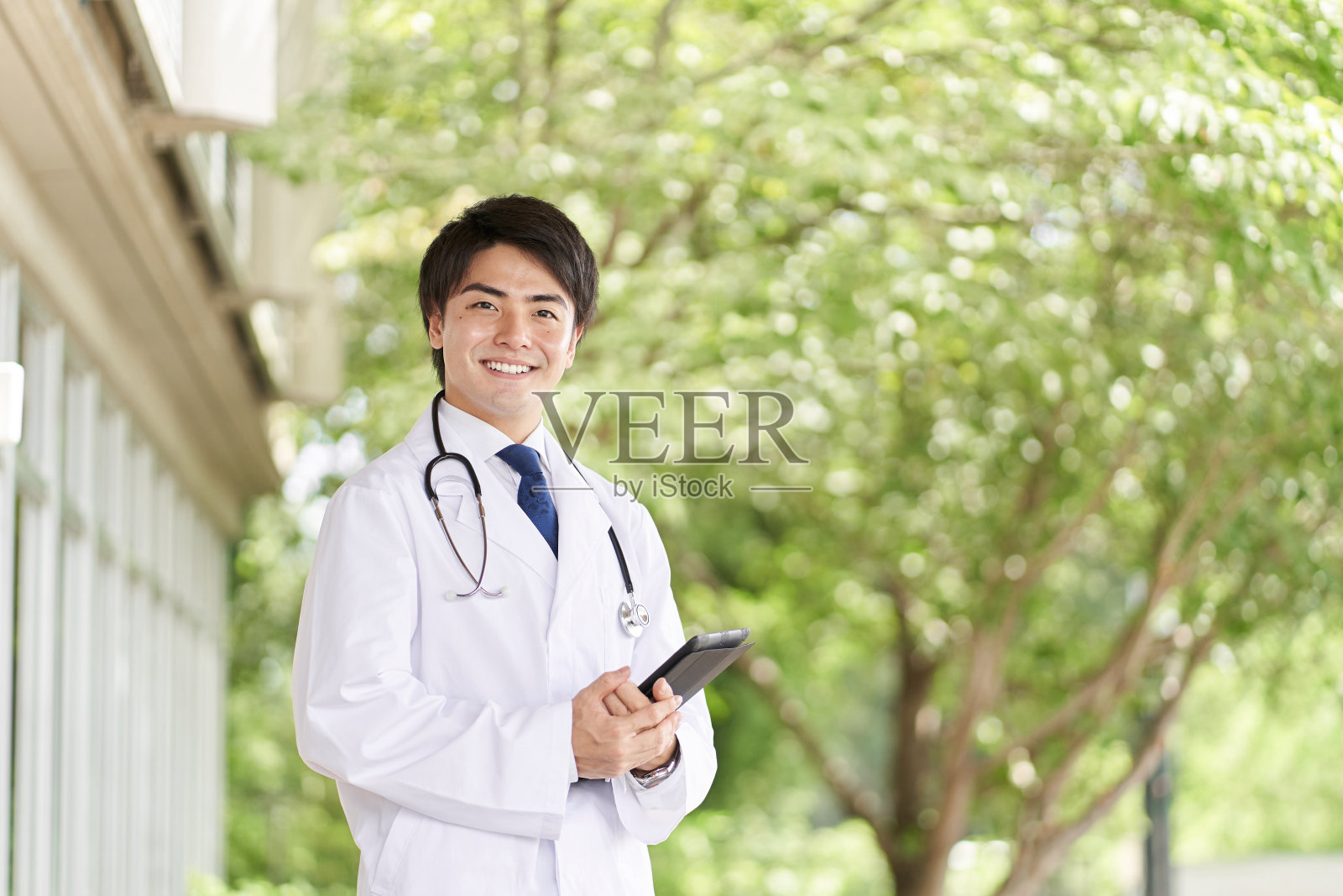 医生微笑着站在绿色背景上照片摄影图片