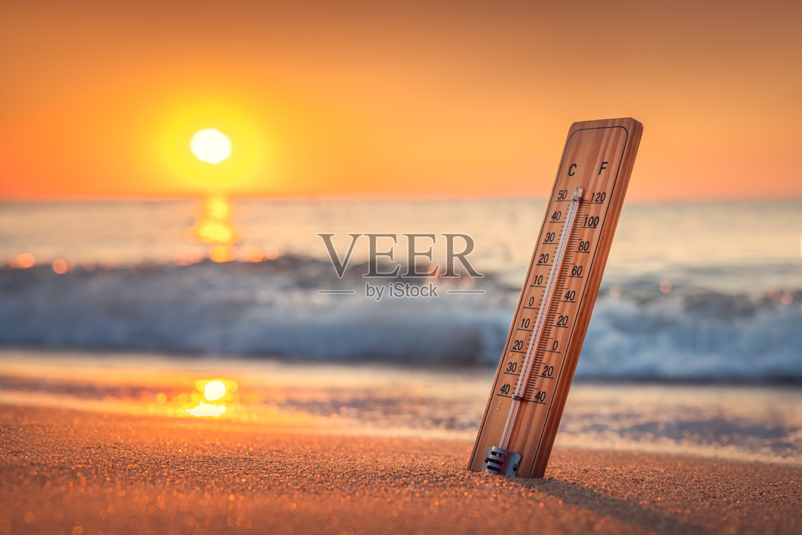 海滩上的温度计和日出。热量。炎热的夏天照片摄影图片
