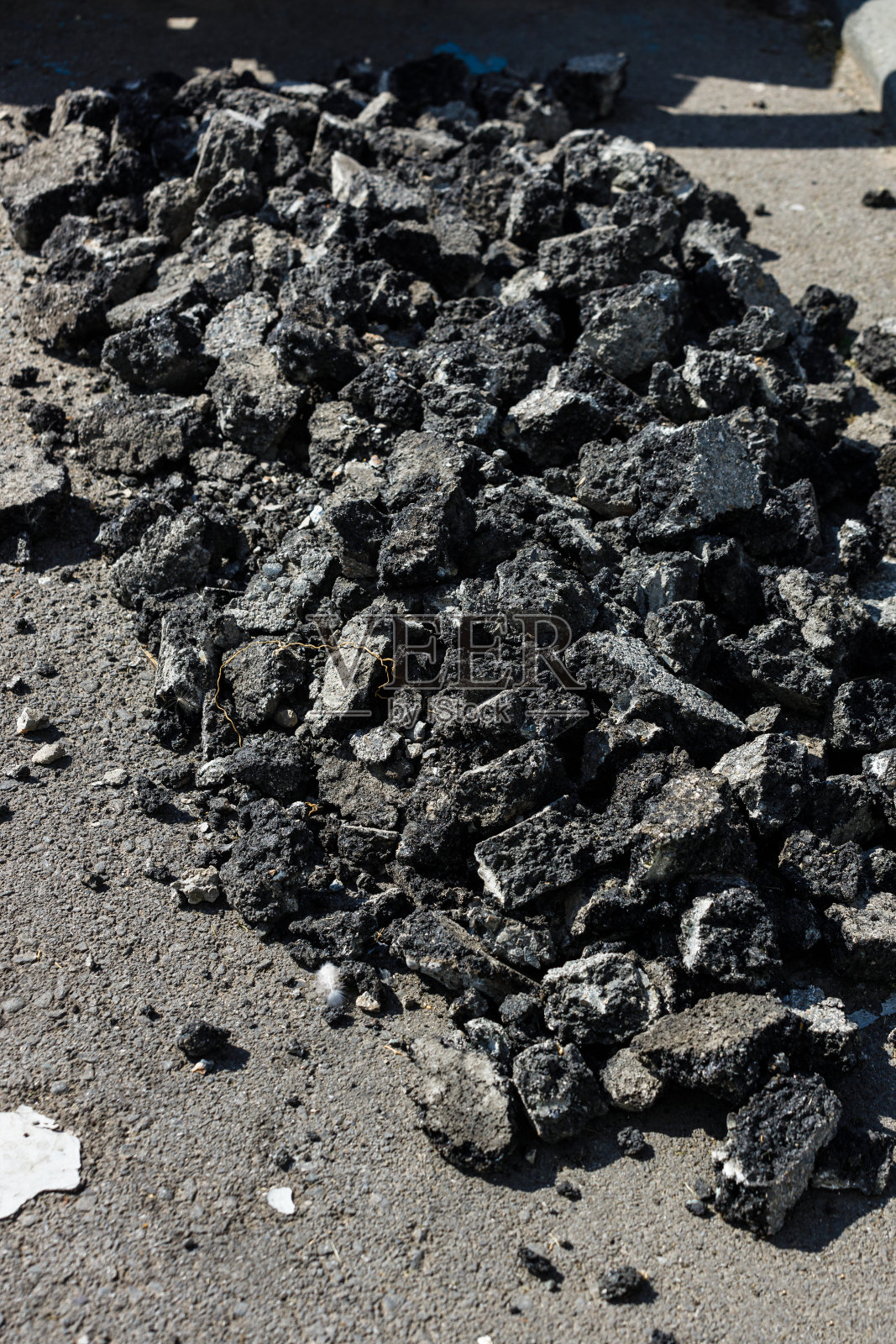 路面维修。路上有一堆用旧柏油铺成的石头。摘要纹理的背景照片摄影图片