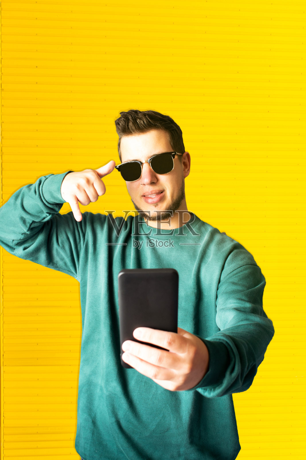 一个年轻人在街上一边挥手一边打视频电话照片摄影图片