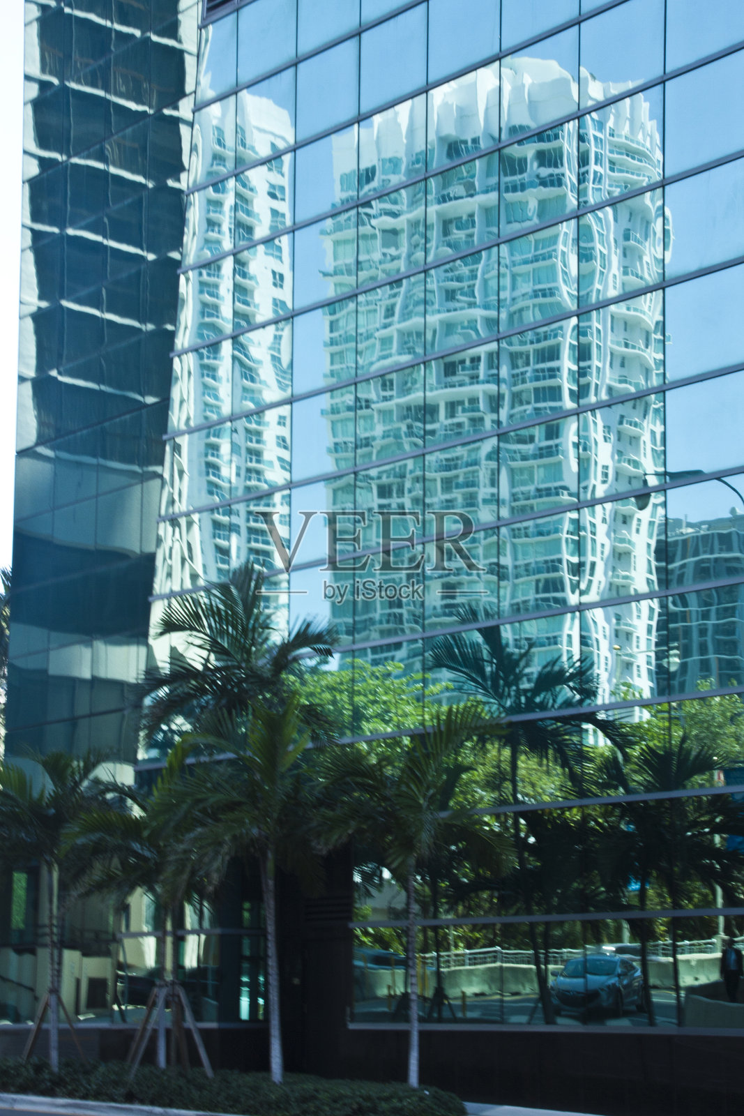 摩天大楼反映在另一座建筑的镜面墙上照片摄影图片