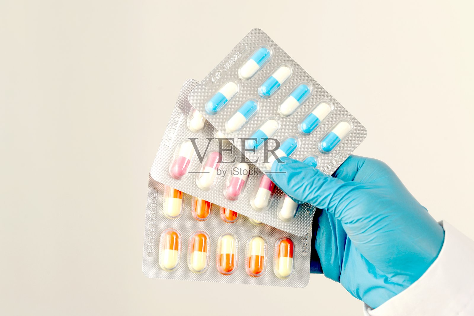 药剂师或医生拿着抗生素胶囊给病人或其他人。过度使用抗生素抗菌素耐药性白色背景照片摄影图片