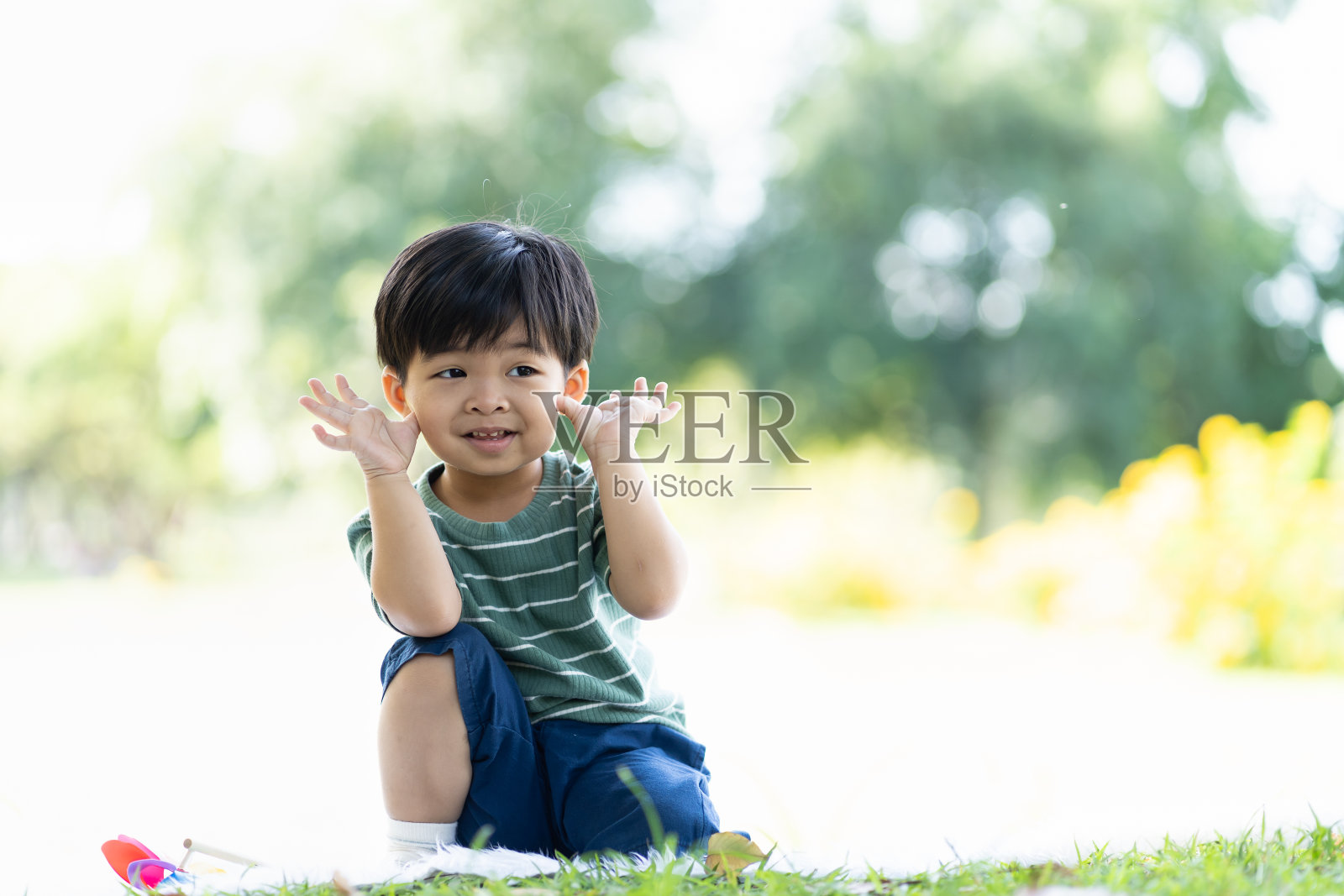 微笑的蹒跚学步的小男孩在户外玩耍。亚洲小孩在公园的草地上玩耍，享受，放松。孩子，游戏，实地考察和教育理念照片摄影图片