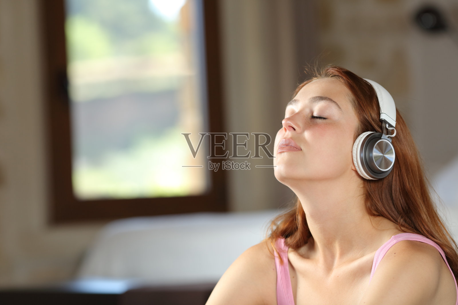 放松的女人在卧室里听音乐照片摄影图片