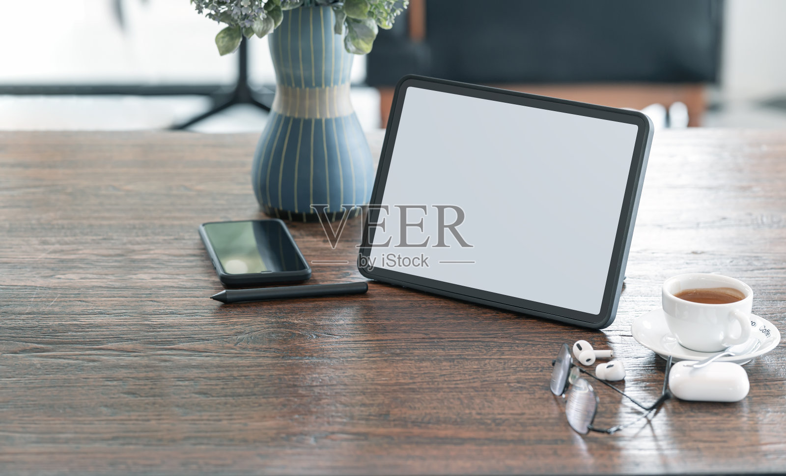 带有复印空间的咖啡室木桌上的空白屏幕平板电脑、小玩意和咖啡杯。照片摄影图片