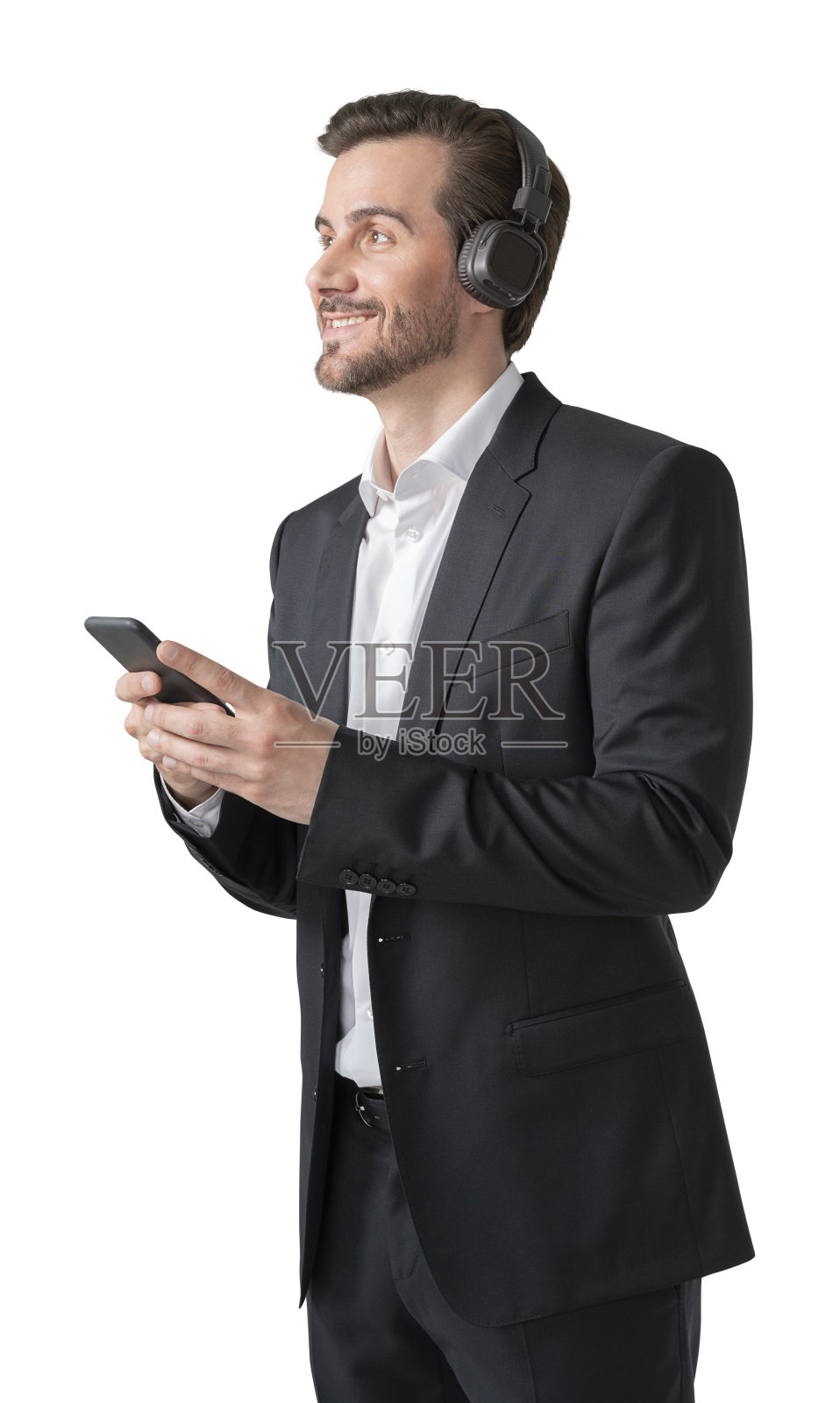 年轻的欧洲人穿着优雅的西装，戴着耳机和智能手机听着音乐，与世隔绝照片摄影图片