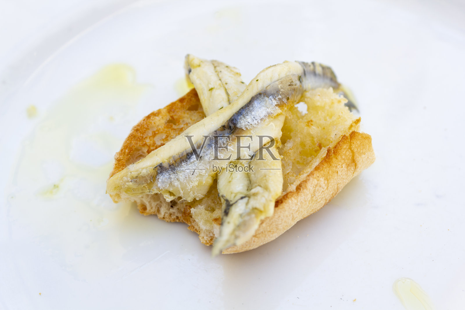 用橄榄油和醋把鱼片放在面包上照片摄影图片