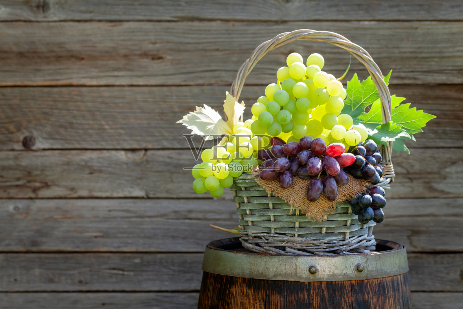 酒桶上有各种颜色的葡萄照片摄影图片