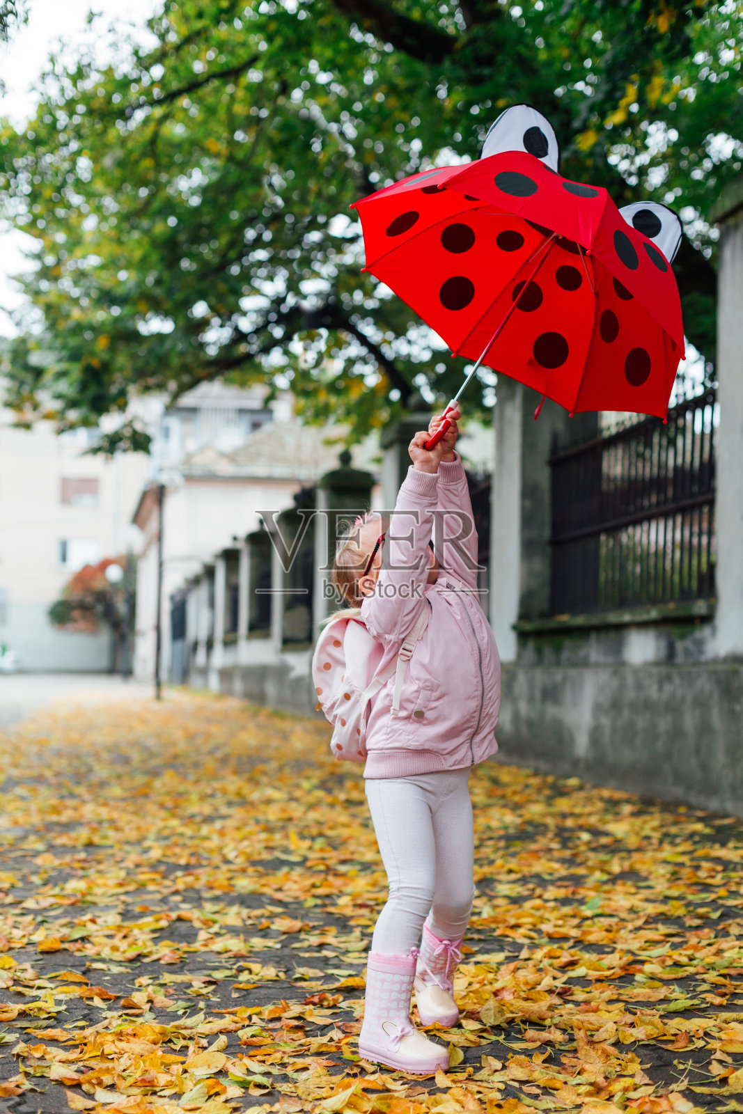 女孩在秋天的街上玩耍照片摄影图片