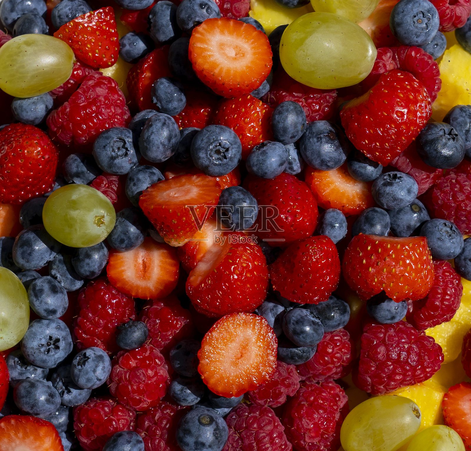 新鲜水果沙拉。葡萄、蓝莓、树莓和草莓。从上面看。健康新鲜水果的背景。夏天的时间照片摄影图片