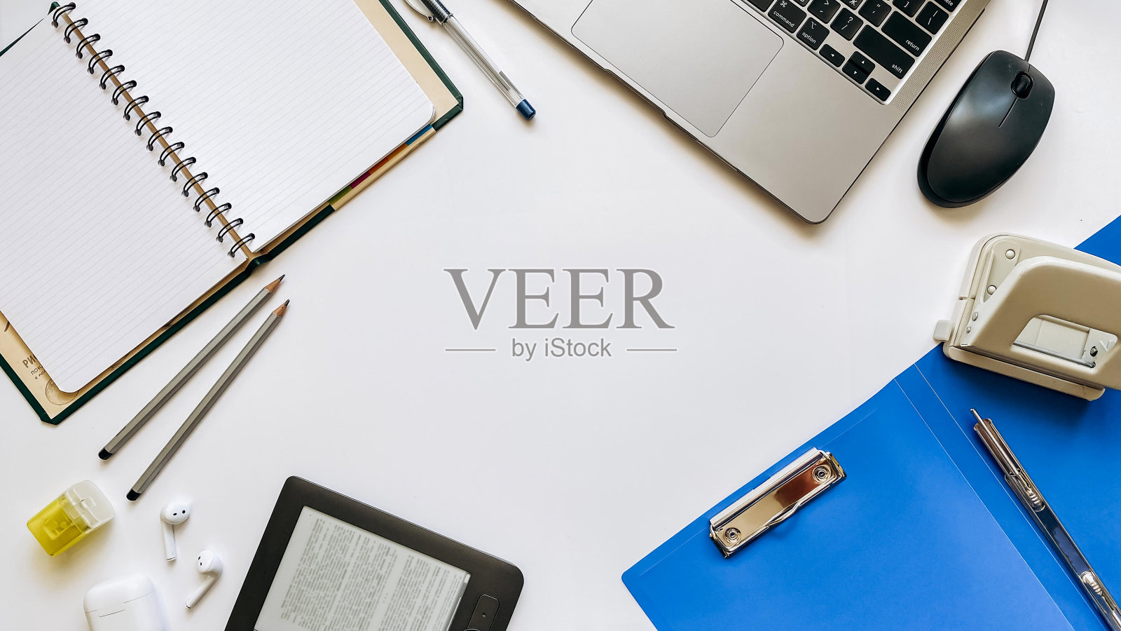 以工作过程或教育为主题，以白色为背景，配有记事本，钢笔，笔记本电脑，鼠标，平板电脑，打孔机，耳机，铅笔照片摄影图片