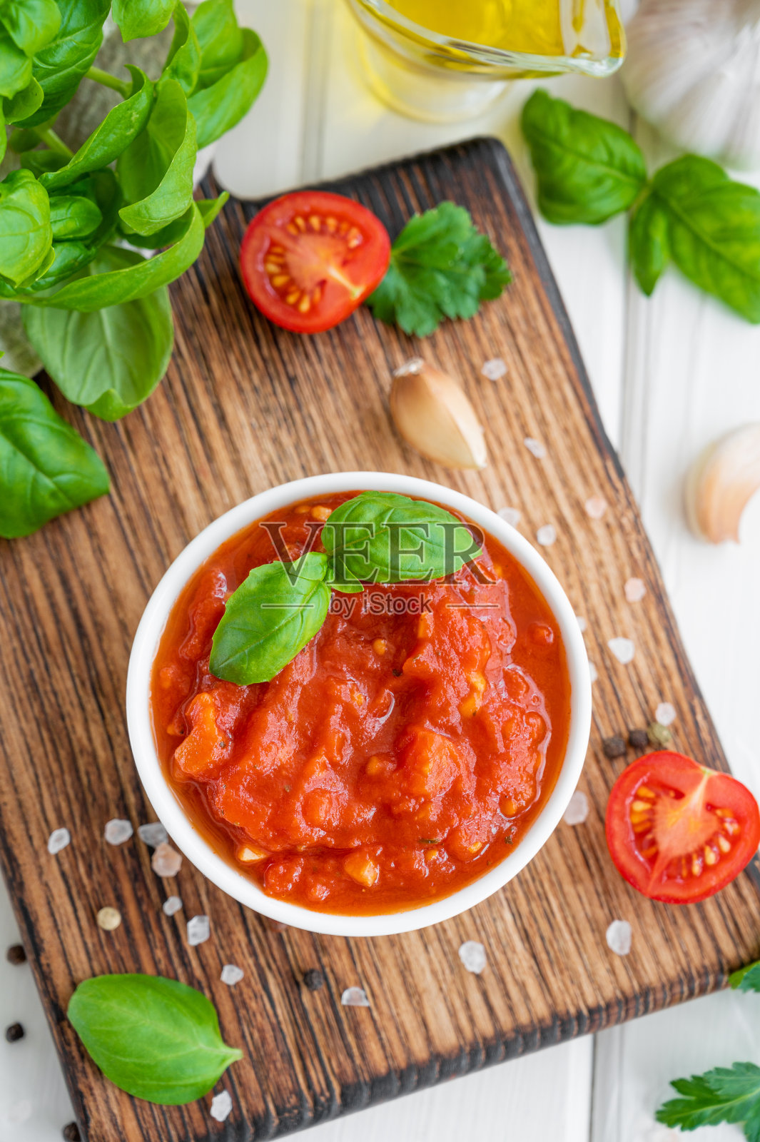 在白色木制背景的碗里，放着传统的意大利番茄酱和香料。前视图。副本的空间。照片摄影图片