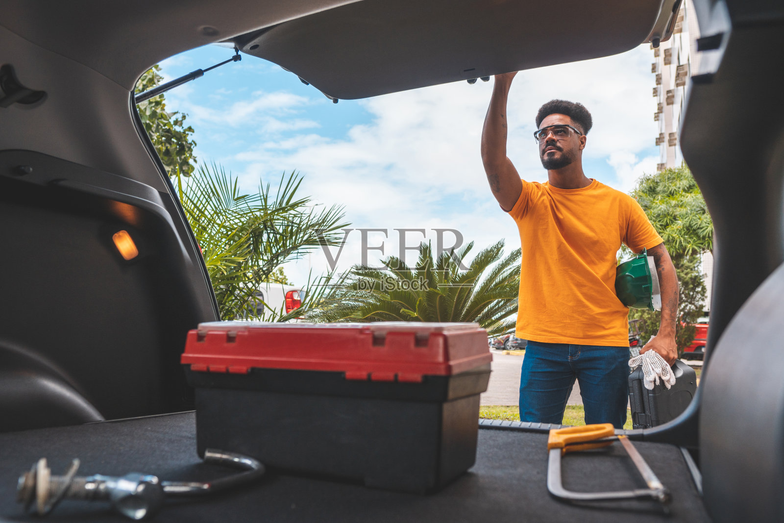 电工水管工正在关闭汽车的后备箱照片摄影图片