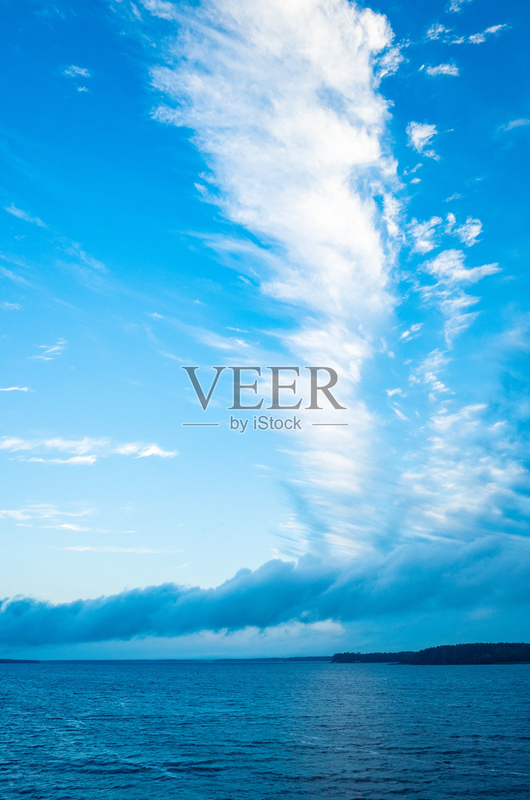 河流景观。平静的海水和巨大的、美丽的、形状奇特的白色云朵。海岸在远处看得见。有一个拷贝空间照片摄影图片