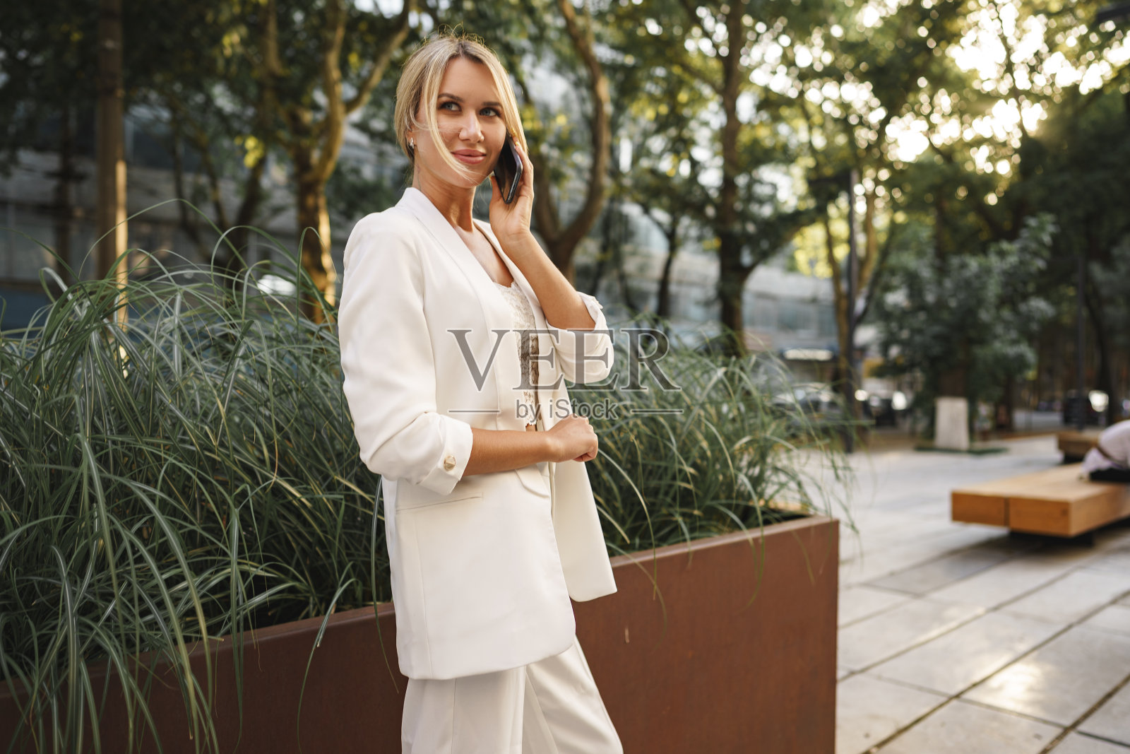 年轻漂亮的金发女商人在城市里使用智能手机照片摄影图片