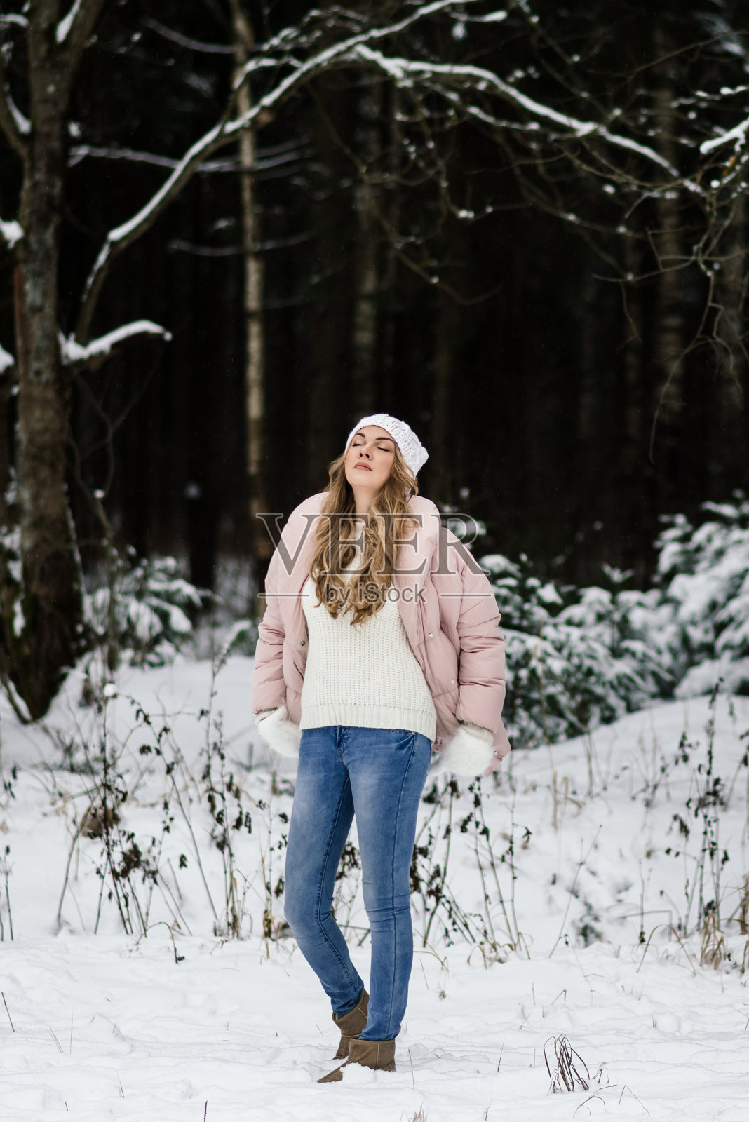 一个美丽的女孩戴着白色的手套，戴着帽子，穿着浅色的衣服，闭着眼睛，抬头望着天空照片摄影图片
