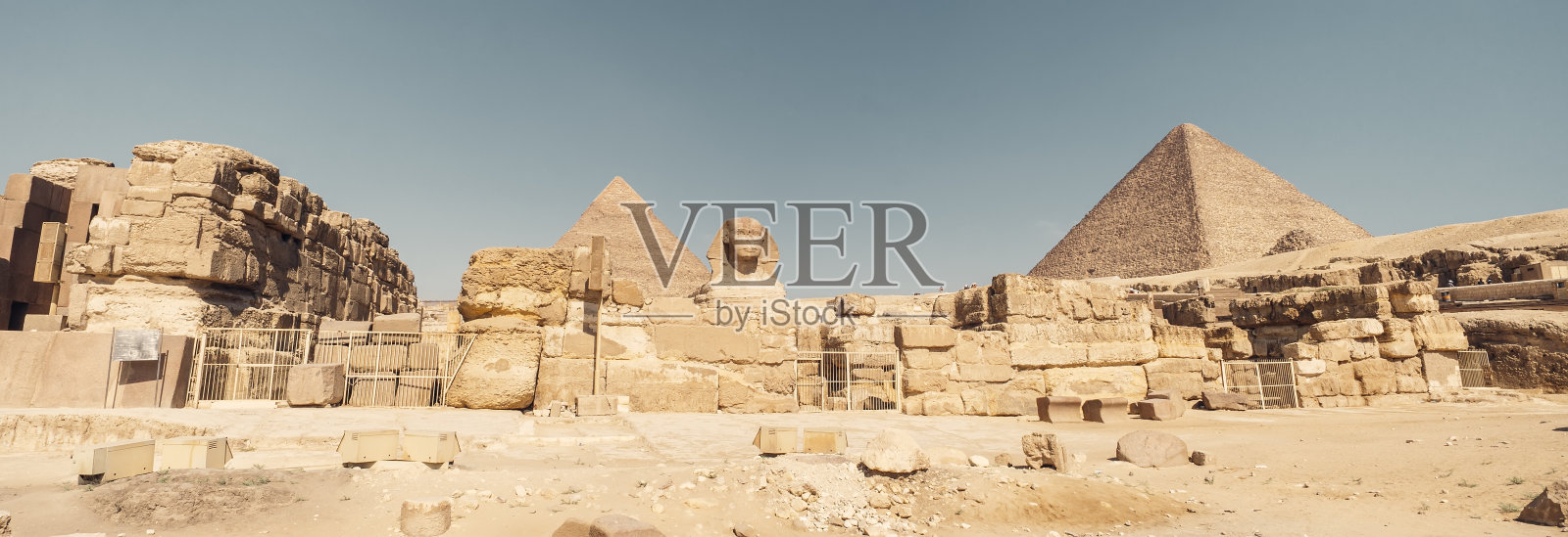 蓝色背景下的古老狮身人面像，毗邻埃及吉萨大金字塔照片摄影图片