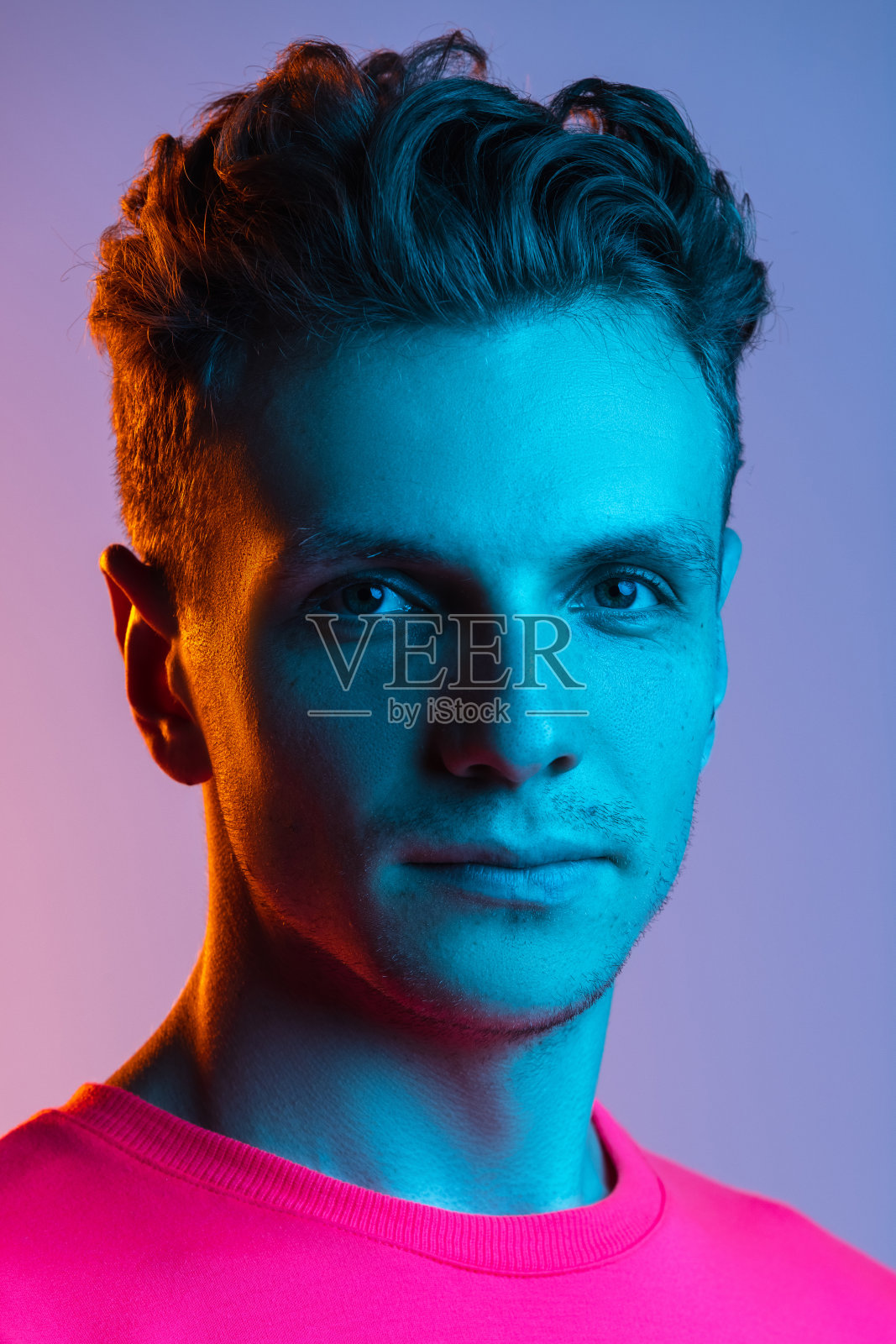 一个白人青年的肖像孤立在紫色的工作室背景。概念人类的情感，面部表情，青春，感情，广告。照片摄影图片