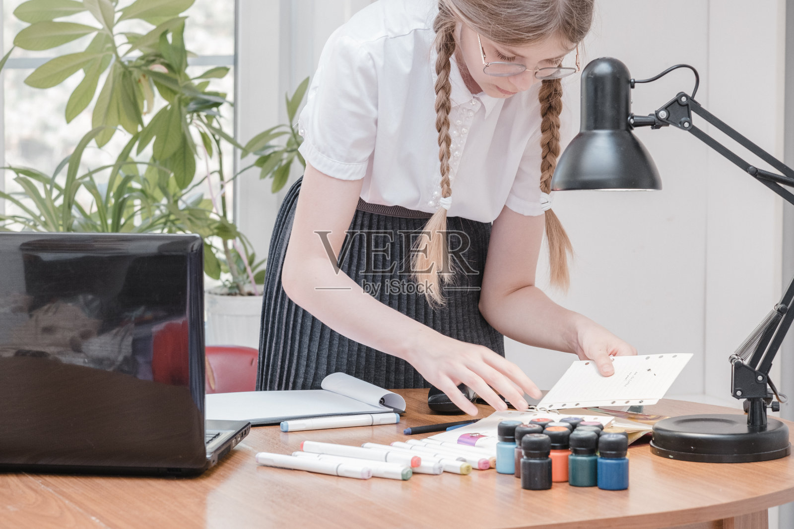 女学生的肖像享受学习在共享办公室使用笔记本电脑做研究，自由职业者在做项目，远程工作做笔记。小学生集中绘画笔记照片摄影图片
