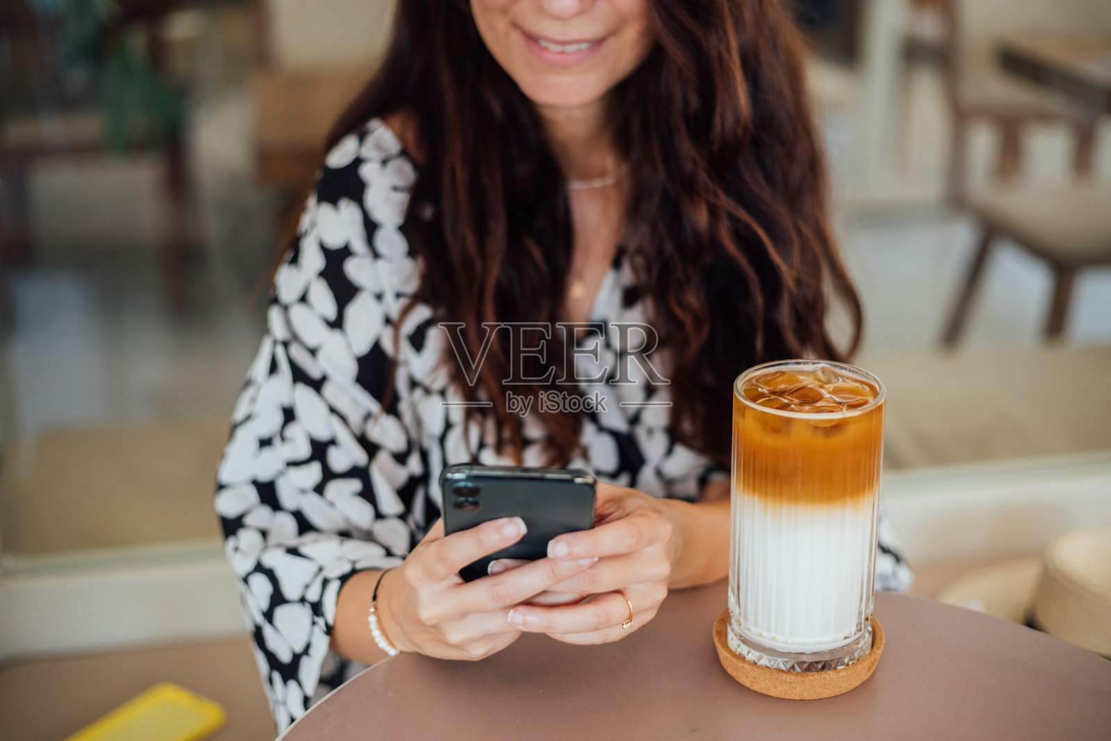 一个女人用手机和朋友发短信，在咖啡馆喝咖啡照片摄影图片