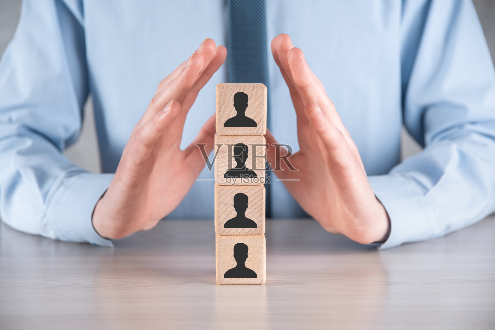 商人手持带有用户图标的木方块放在灰色桌子上。空间的文本。Internet图标界面前景。全球网络媒体概念，虚拟屏幕上的接触，复制空间照片摄影图片