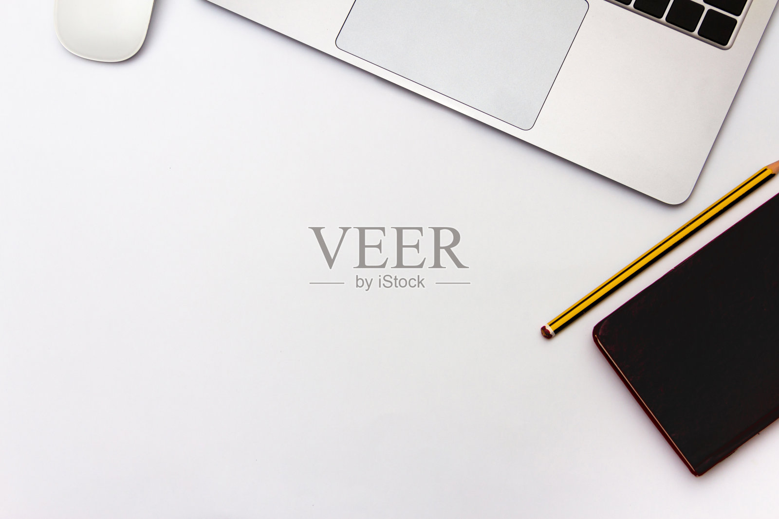 笔记本电脑与鼠标，笔记本和铅笔在白色背景。办公室的概念。前视图。平的。副本的空间。照片摄影图片