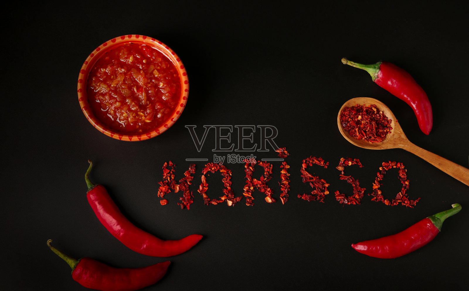 哈里萨辣酱，深色背景上有辣椒，突尼斯和阿拉伯美食，干辣椒的哈里萨字，俯视图。照片摄影图片