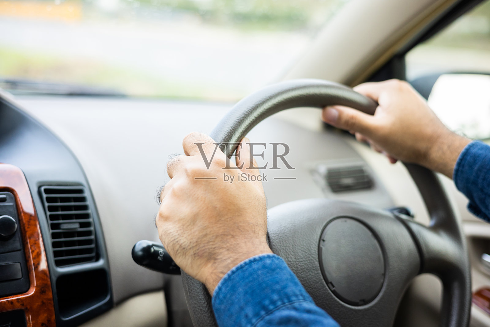 年轻人得到新车手握着汽车的方向盘安全驾驶旅行。照片摄影图片