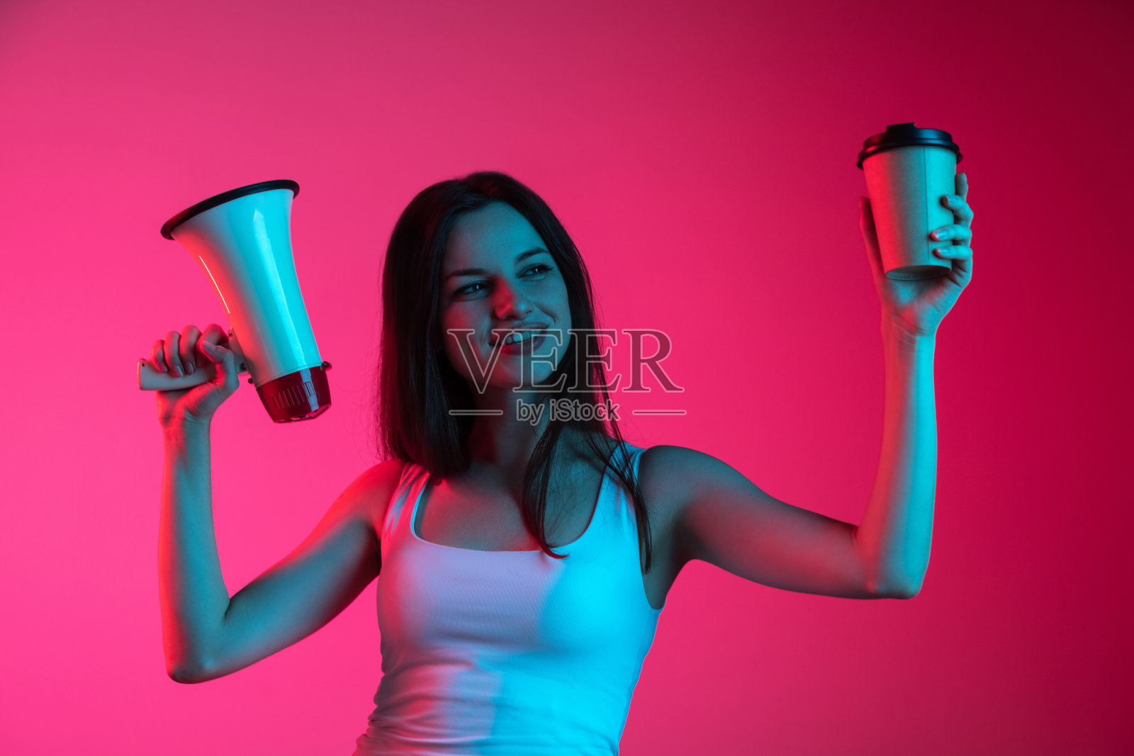 裁剪图像的年轻女孩提高扩音器和纸板上的渐变粉红色背景霓虹灯。休息的时间照片摄影图片