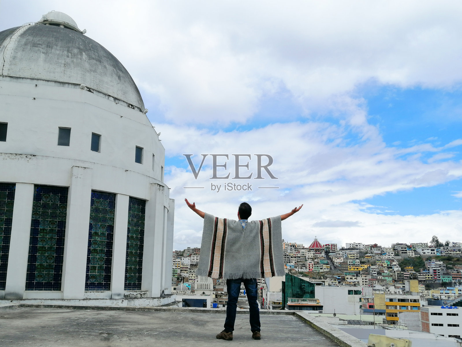 拉丁背包客在旅行时张开双臂，在厄瓜多尔通古拉瓦的安巴托周围放松和享受旅程;背面，城市景观在晴天多云的日子。照片摄影图片