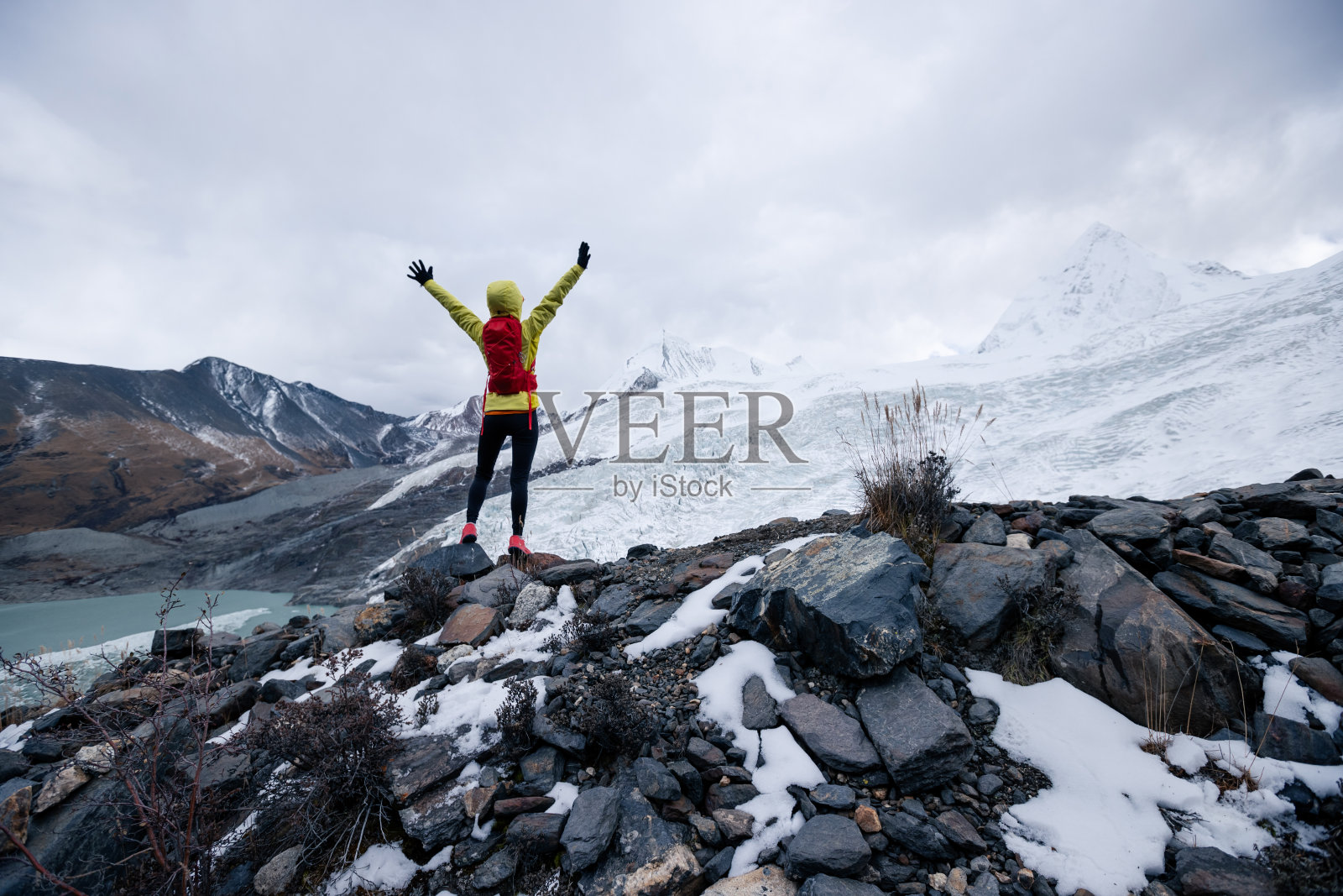 成功的女性步行者向冬天的化石冰川雪山张开双臂照片摄影图片