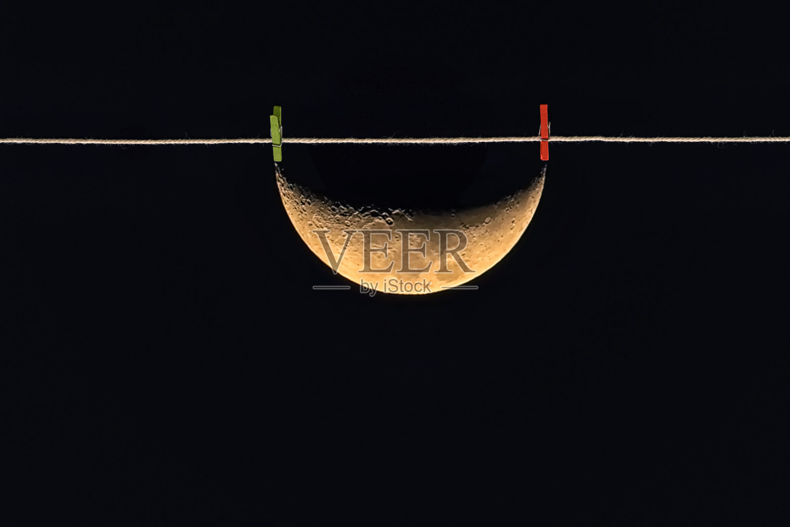 夜空中洗衣绳上的半月形照片摄影图片