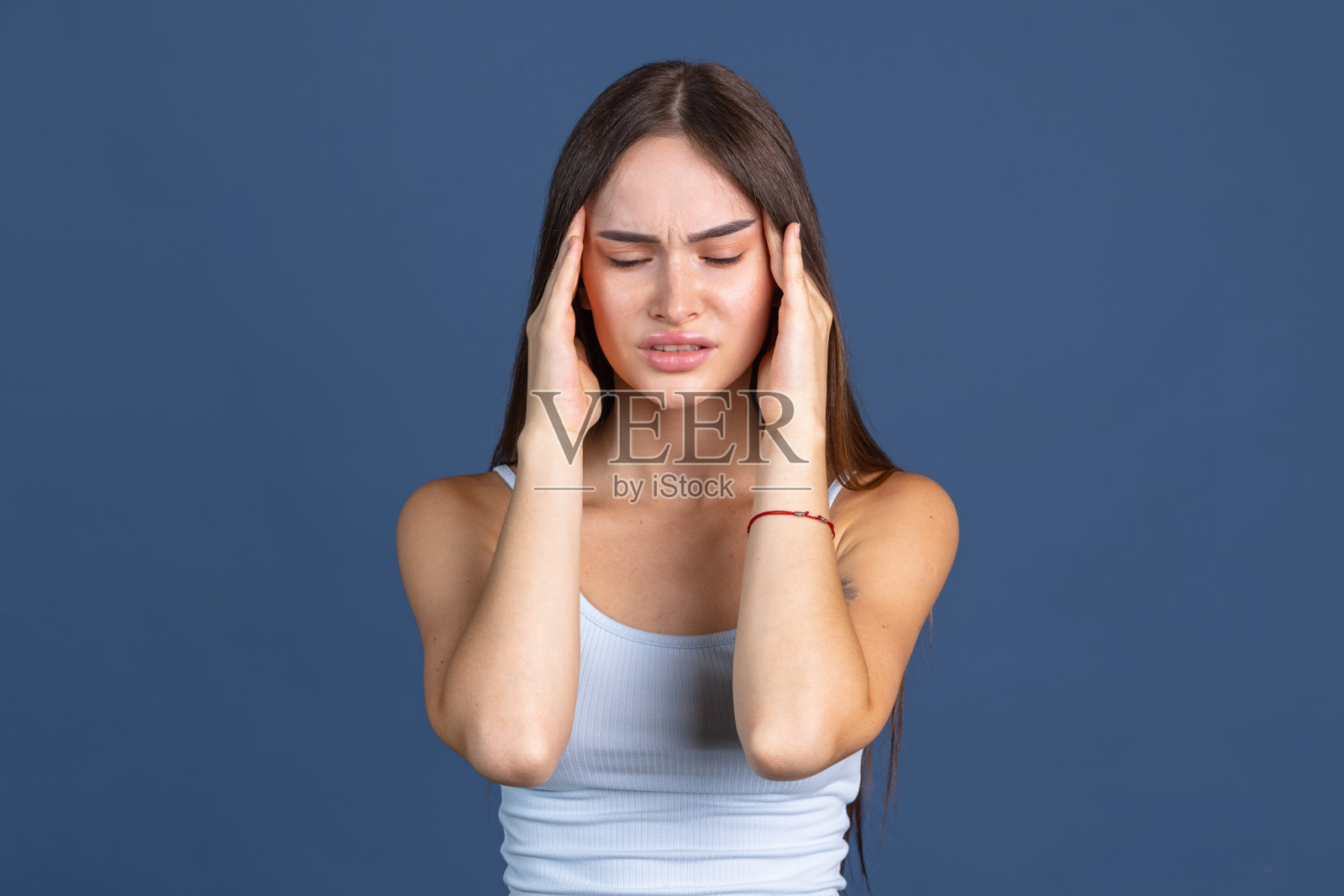 压力。年轻美丽的女人的裁剪肖像在深蓝色的背景照片摄影图片