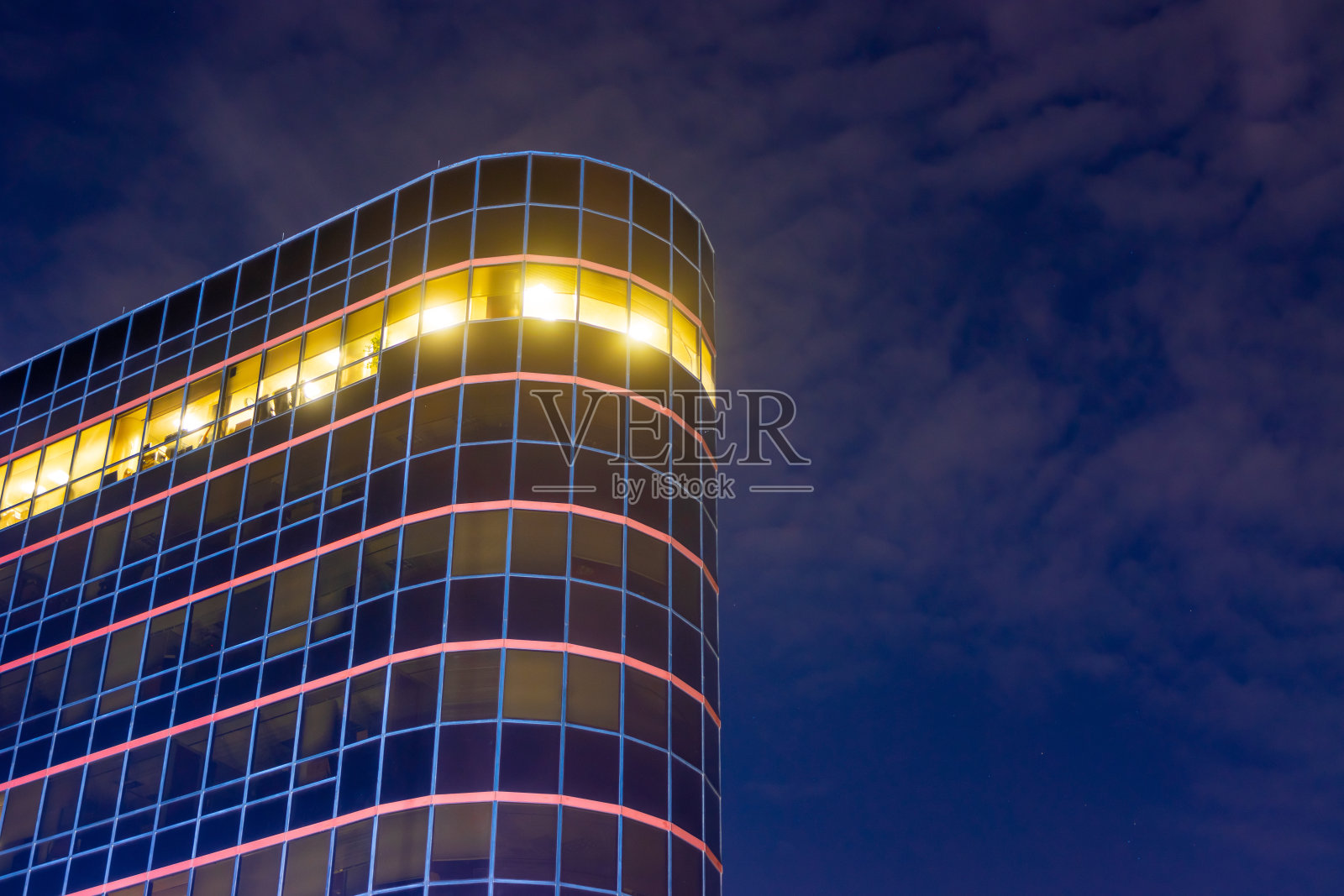 夜晚的圆形建筑，顶层有灯光照片摄影图片