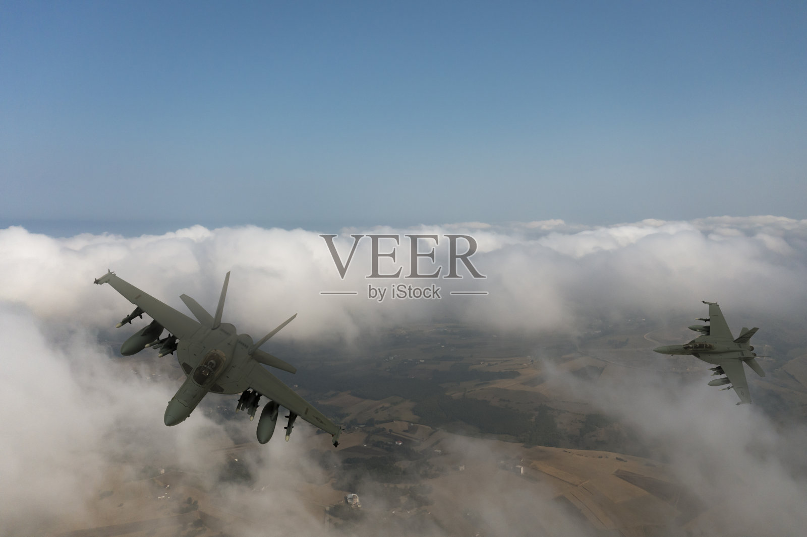 喷气式战斗机在云层上飞行。照片摄影图片