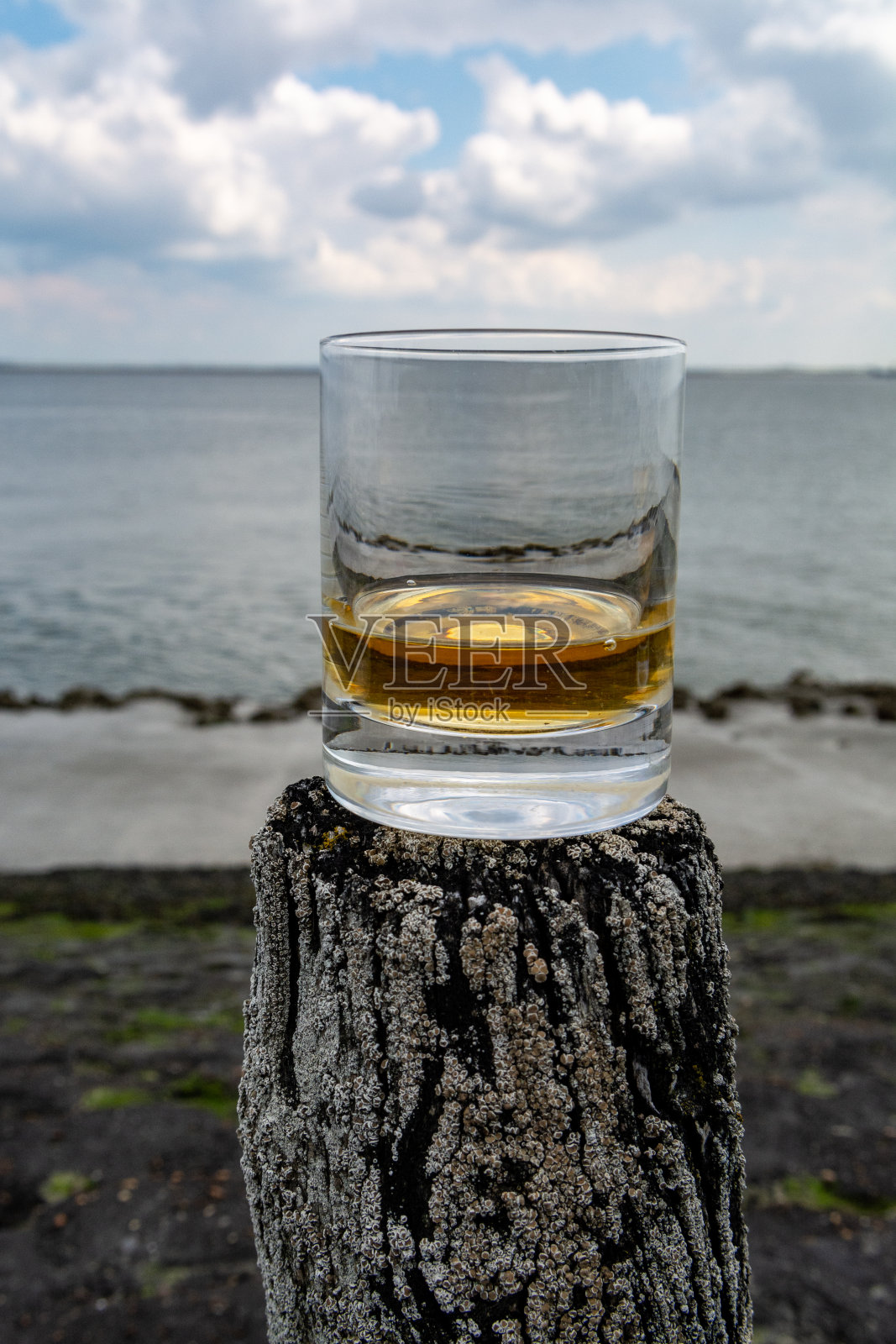 在苏格兰的海滨品尝威士忌，用古老的木杆和威士忌酒杯照片摄影图片