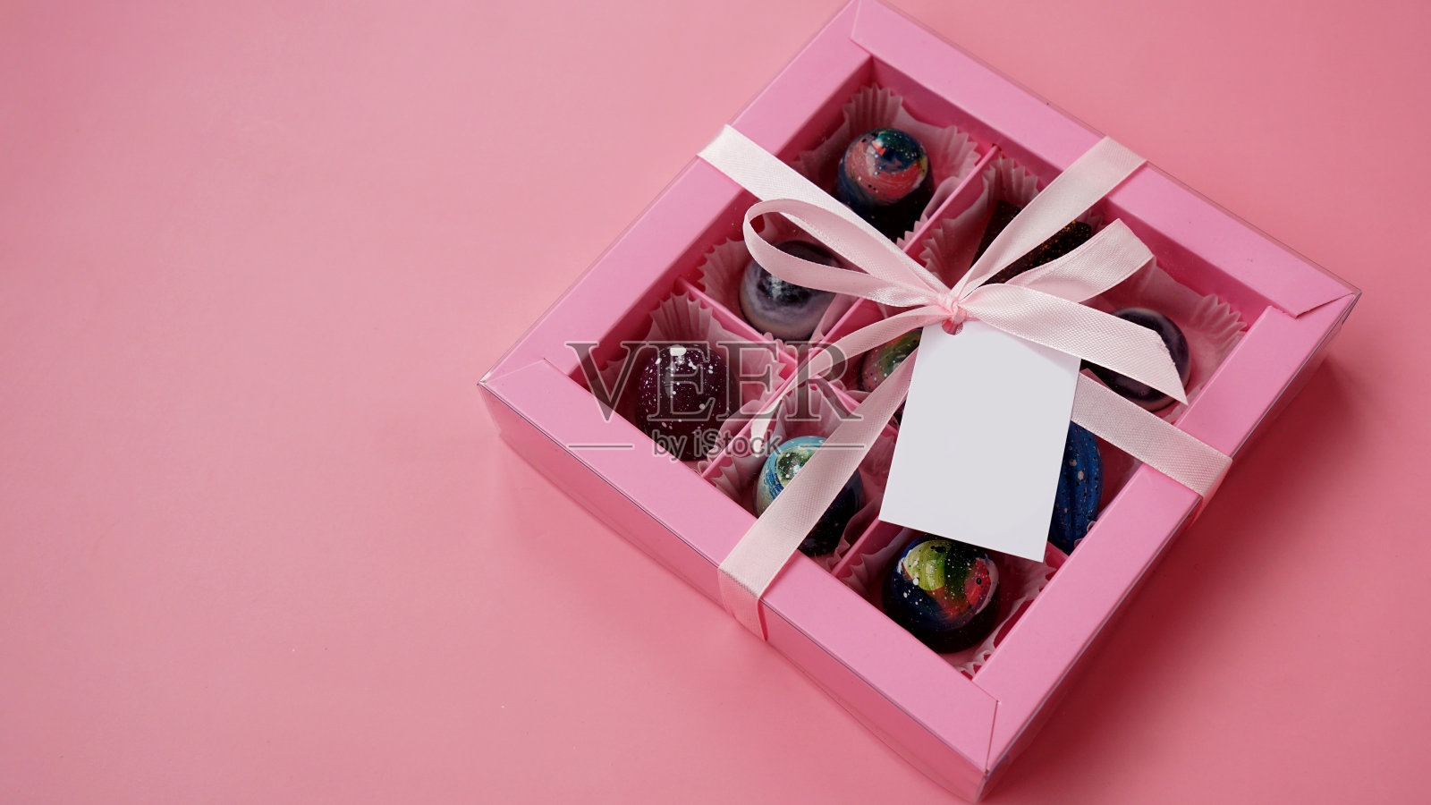 巧克力糖果。粉色礼品盒上有手工制作的粉色巧克力照片摄影图片