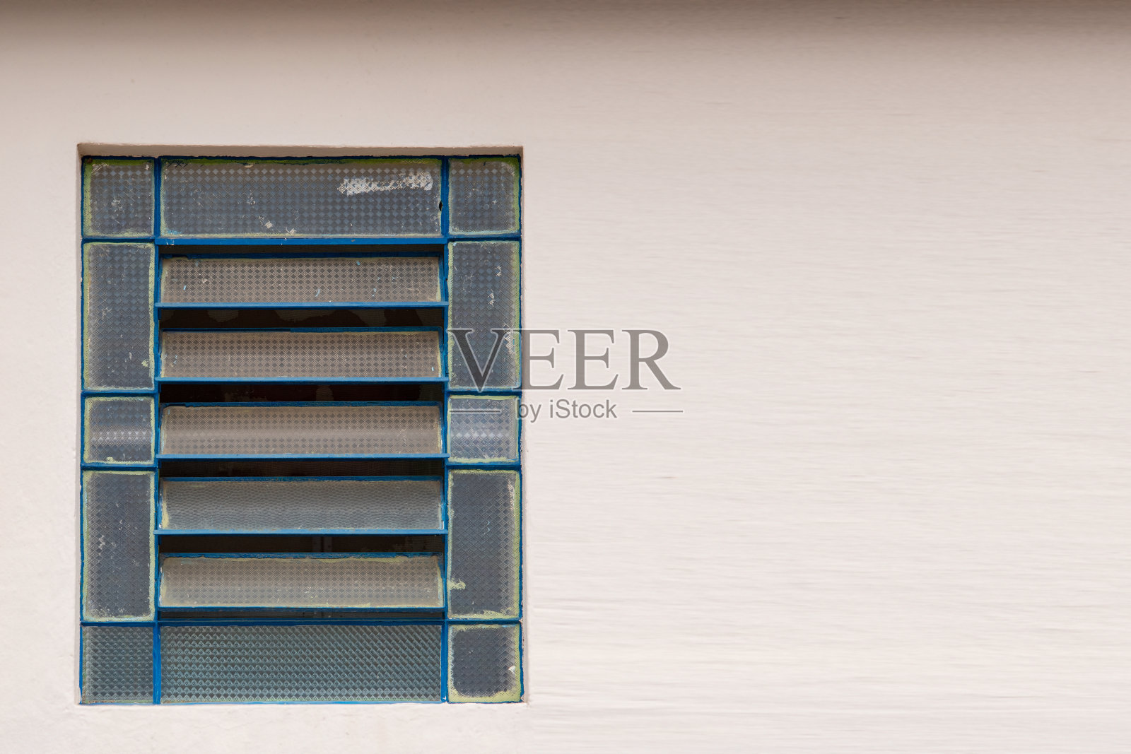 白色墙壁上有铁框的倾斜窗照片摄影图片