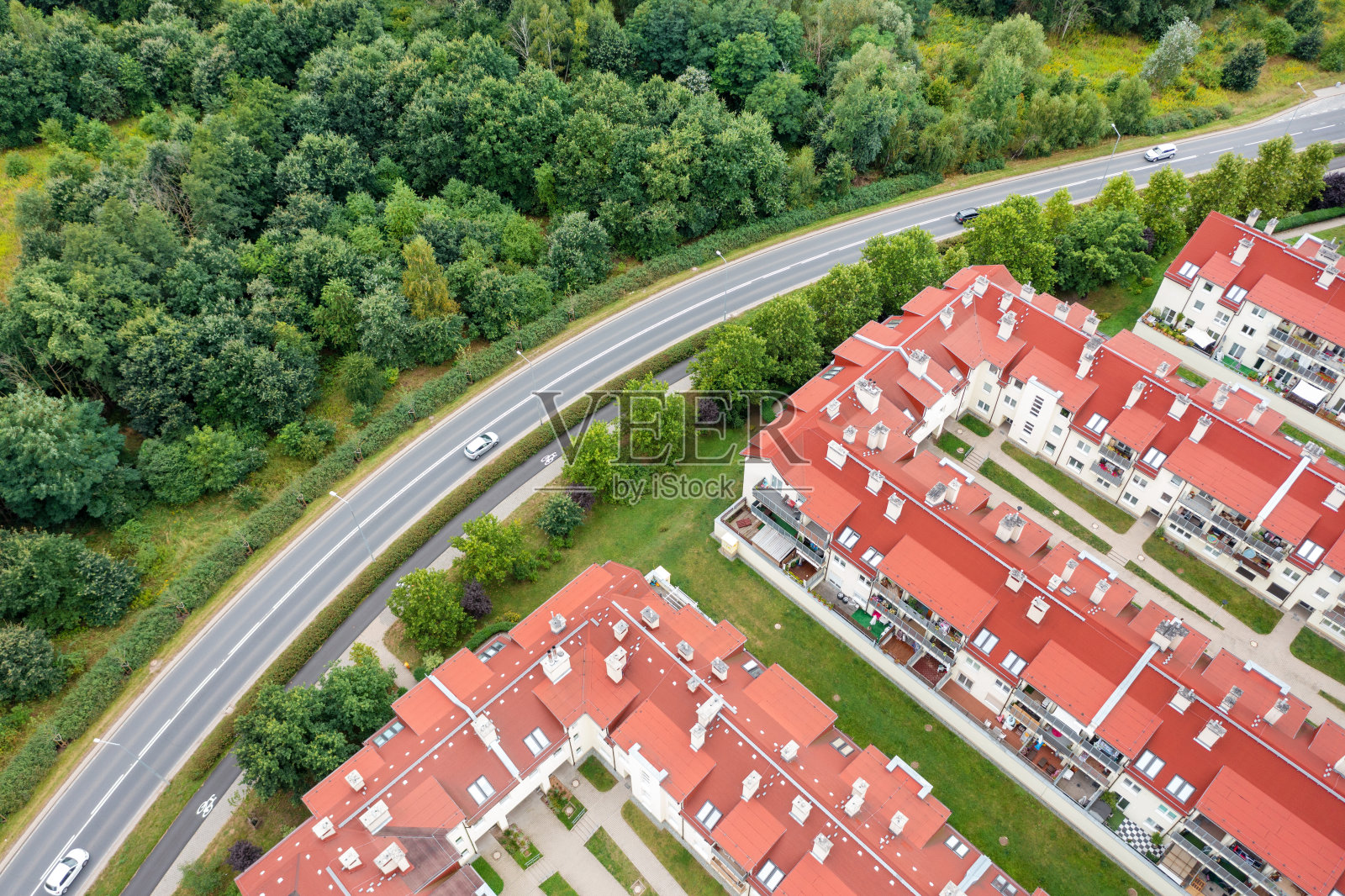 从红色房屋的高度和旁边的森林与道路，夏季景观，无人机照片摄影图片
