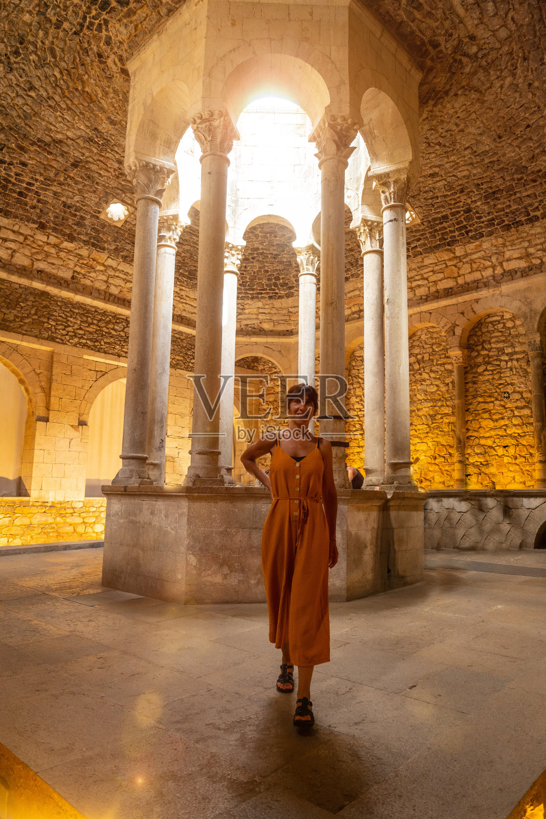 赫罗纳中世纪城市，一名年轻的游客在地中海加泰罗尼亚的布拉瓦科斯塔的阿拉伯Banys内部度假。西班牙照片摄影图片