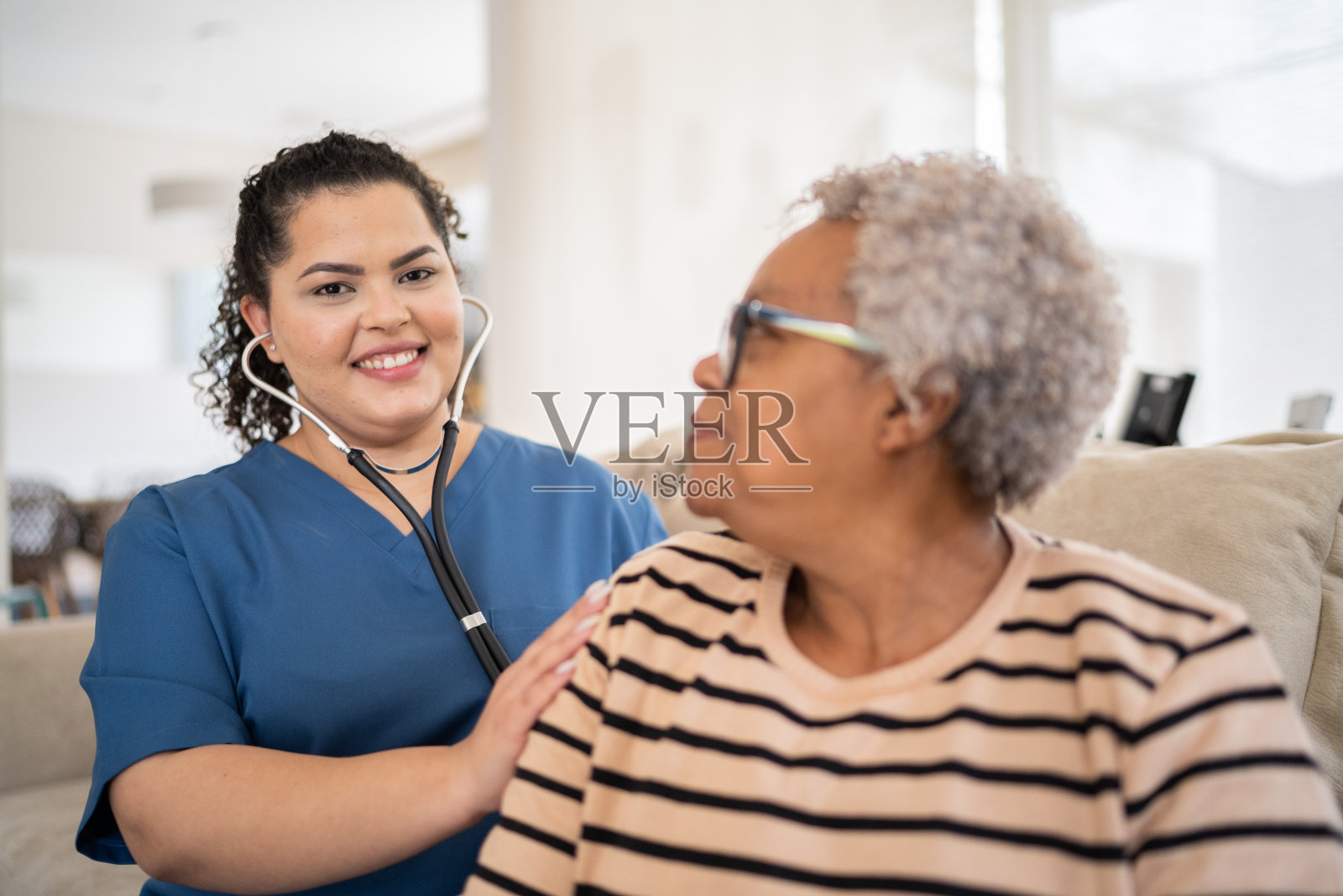 家访时，护士倾听老年病人的心跳照片摄影图片