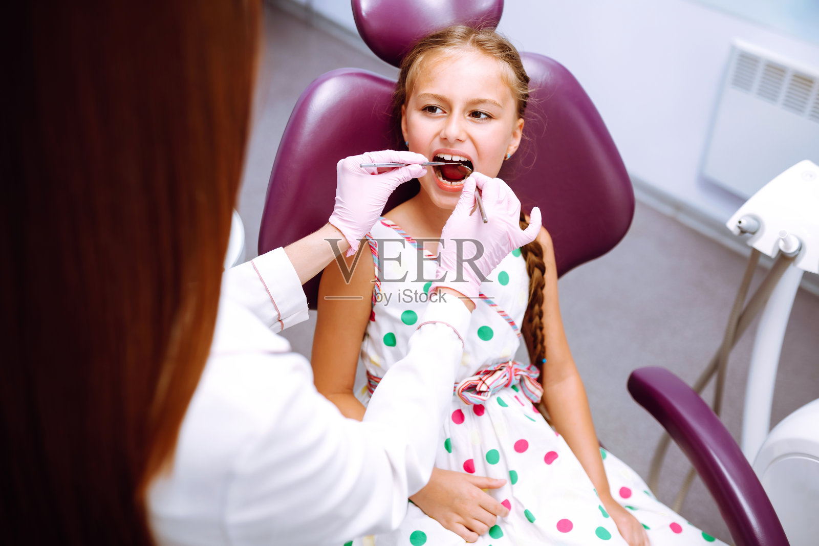 小女孩去看牙医。口腔检查儿童的口腔和牙齿的检查照片摄影图片