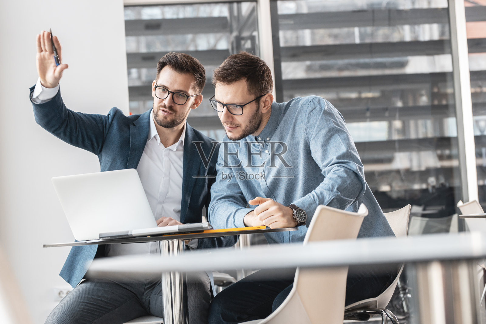 两个办公室职员在讨论公司的新项目。照片摄影图片