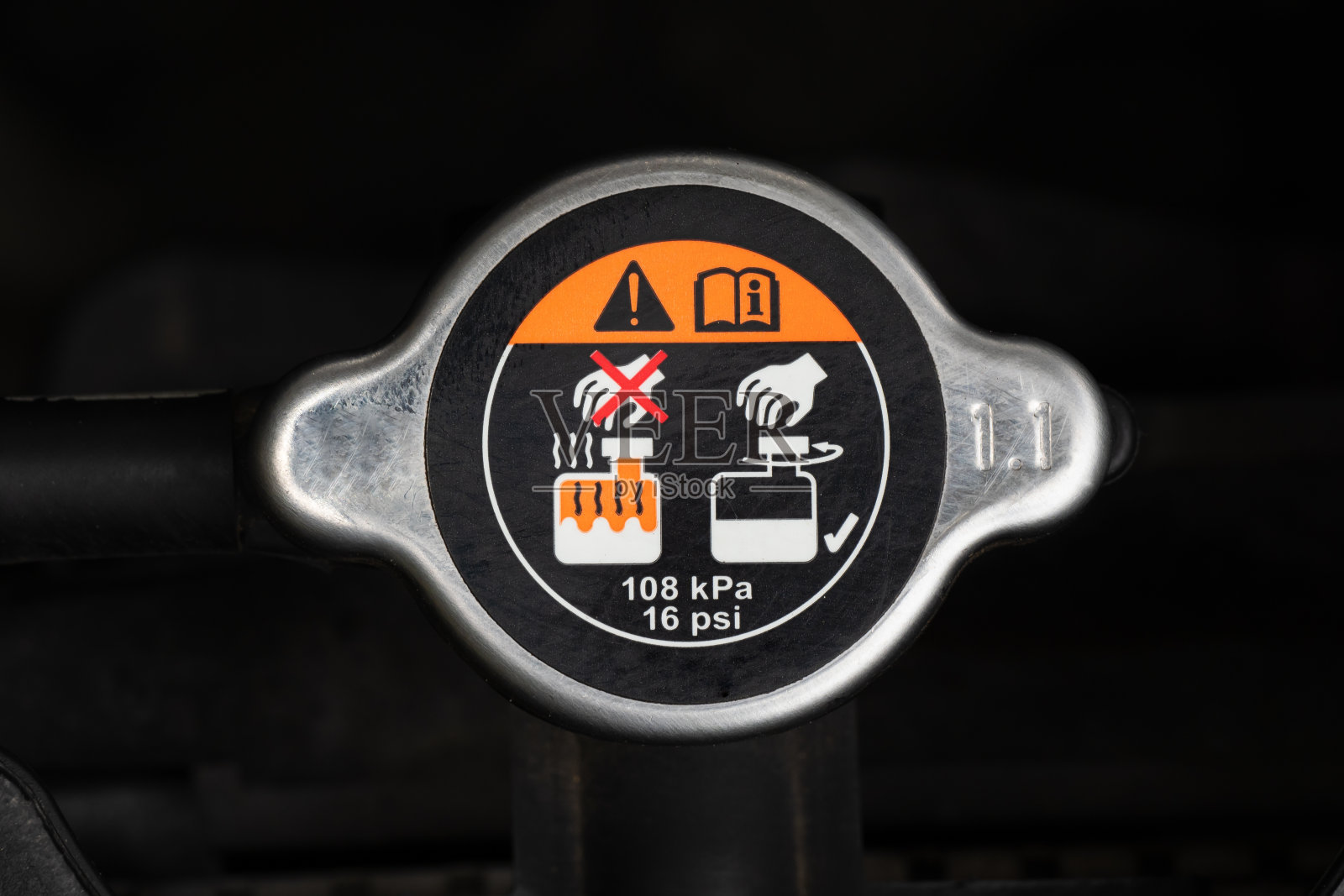 汽车发动机中带有警告标签的散热器盖的金属盖。一个汽车保养和维修的概念。汽车概念的组件。照片摄影图片