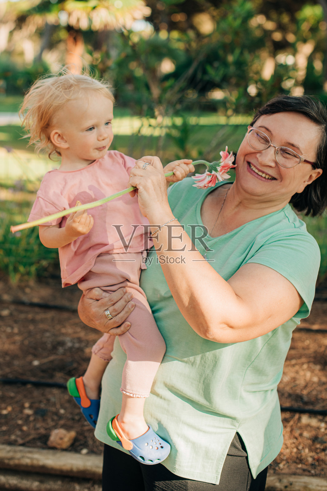 快乐的女人和婴儿在公园散步的肖像照片摄影图片