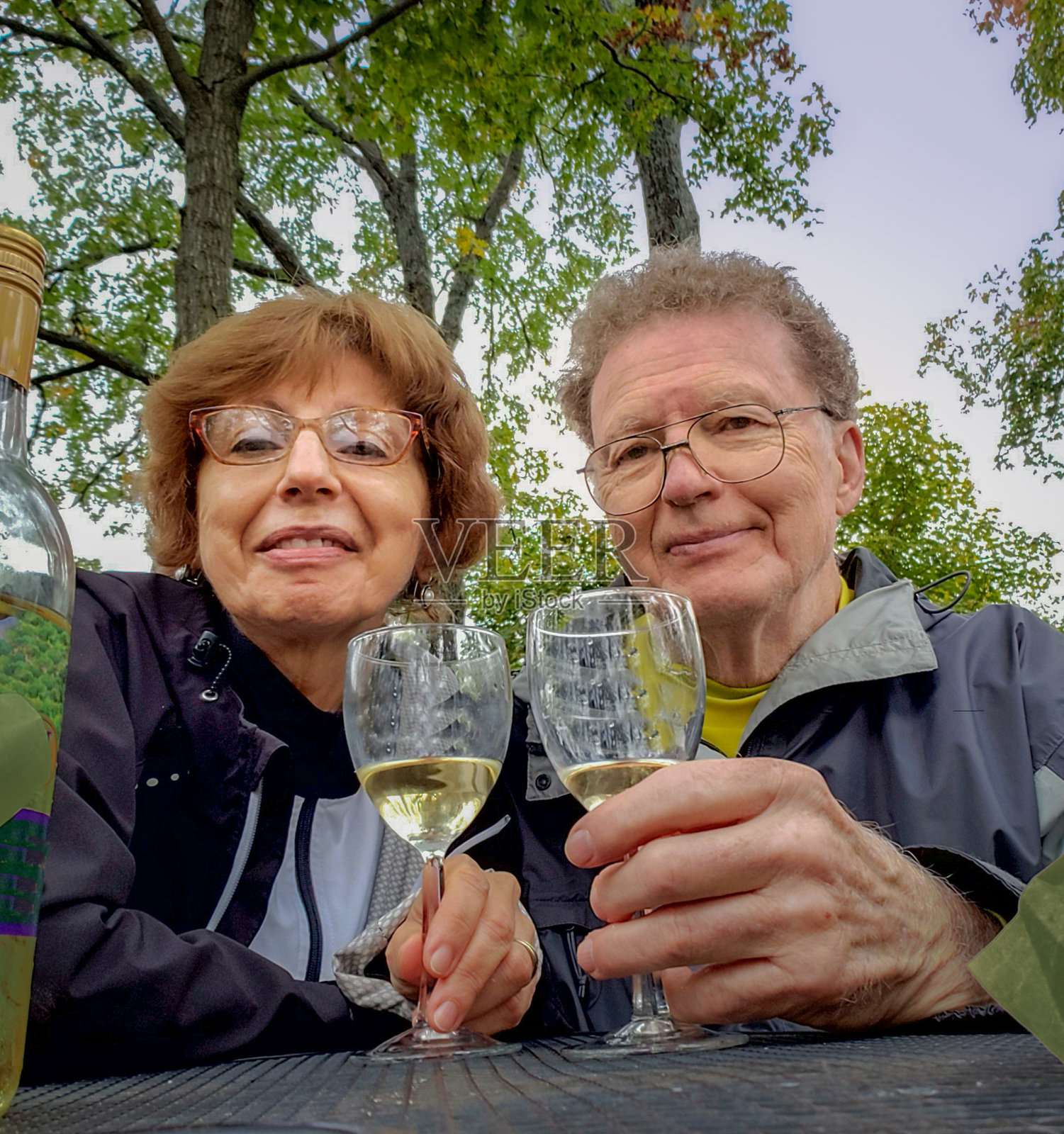 秋酒节期间，微笑的老夫妇在户外饮酒照片摄影图片